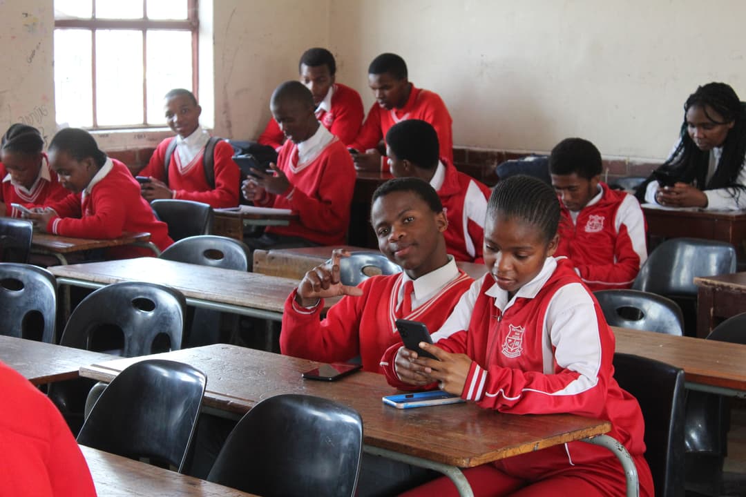 Learners in class with their phones